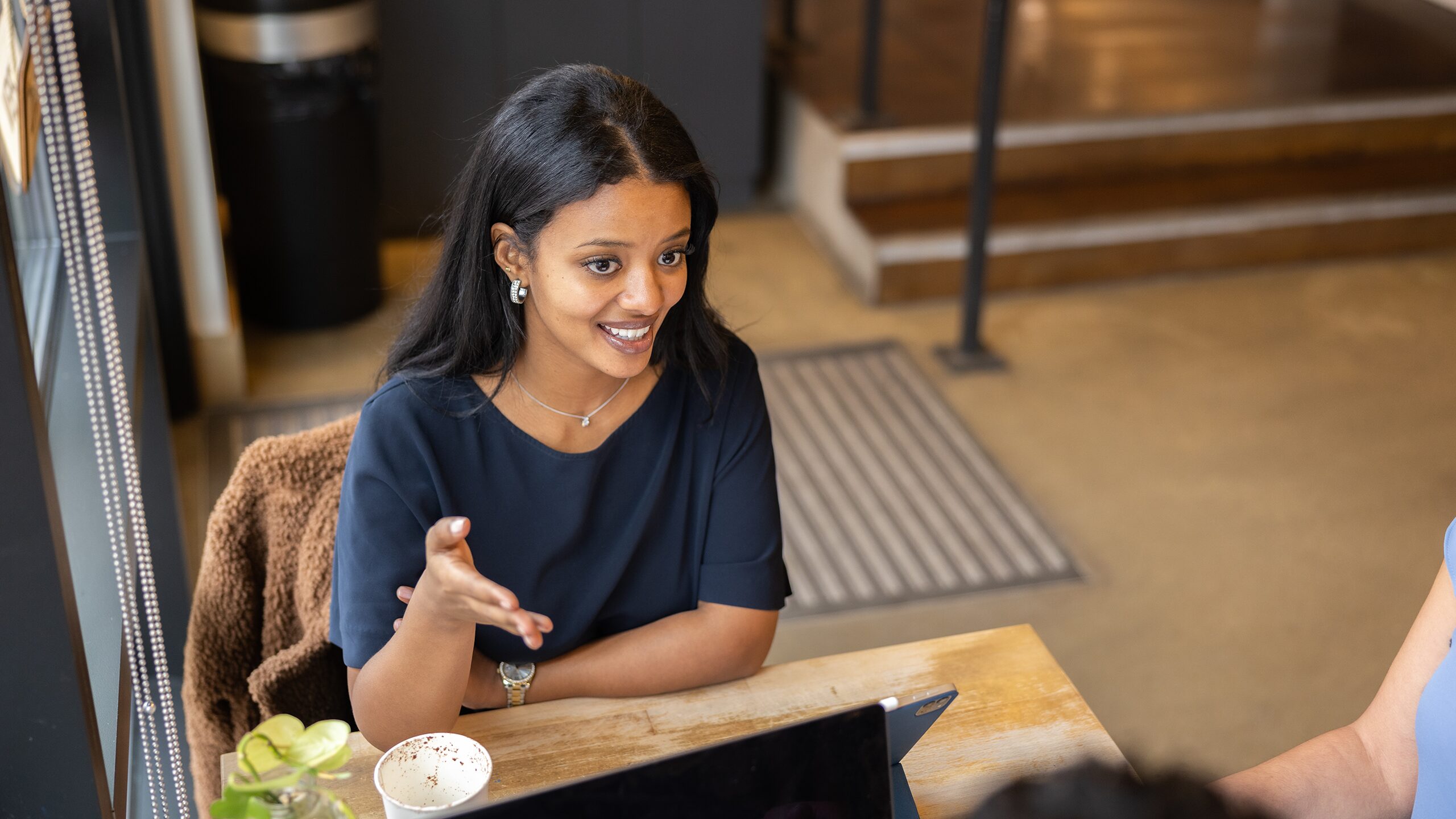 Woman with laptop working in the cafeteria.